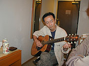板橋センターホテルの部屋でギターを弾く橋本。だがこのメールをやりとりしていた時点では考えられない光景である...